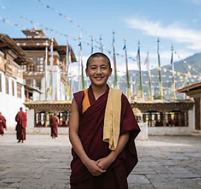 Young monk before prayer flags